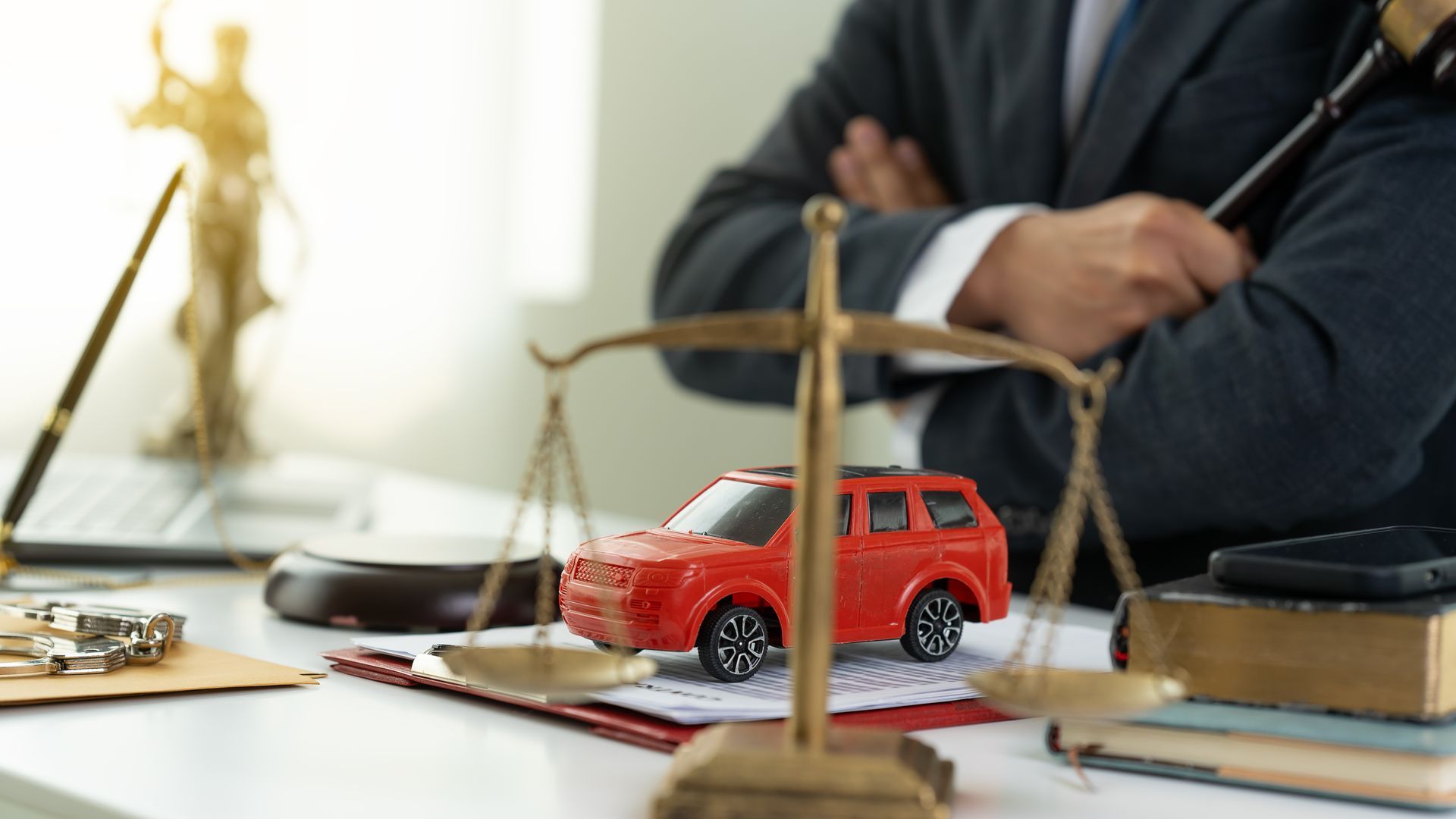 Auto accident attorney desk with justice scale symbolizing legal case review.