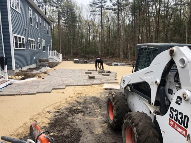 A bobcat s330 skid steer is parked in front of a house that Able's Landscaping is working on