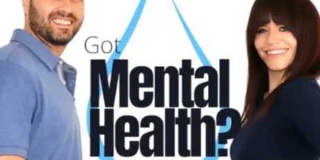 A man and a woman are standing in front of a sign that says got mental health