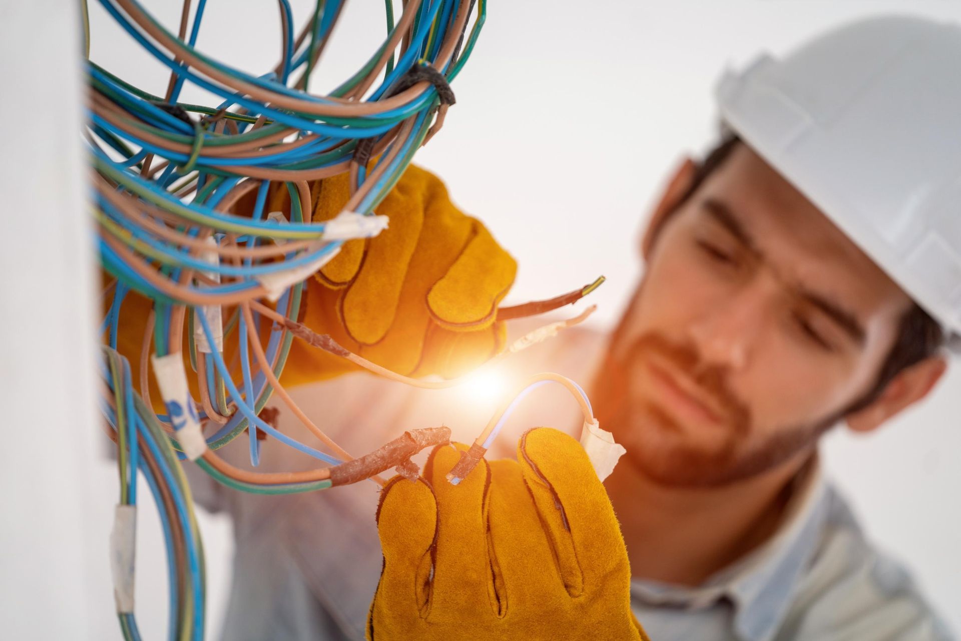 An electrician is working on a wall with wires.