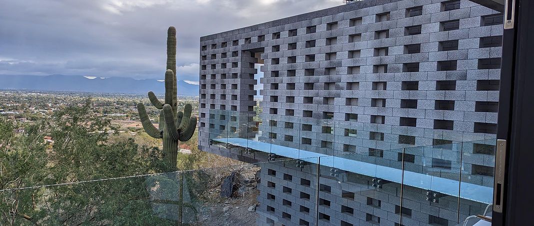 A building with a cactus in front of it and a view of a city.