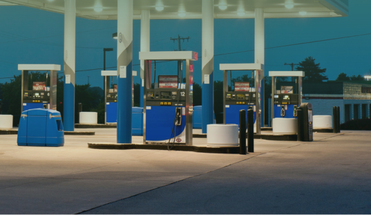 A gas station with three lanes of fuel pumps.