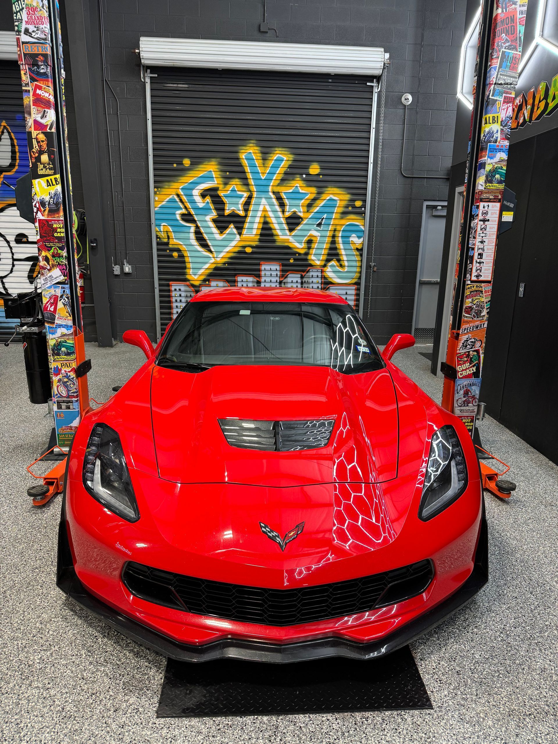 Red Corvette sports car parked in a garage with 