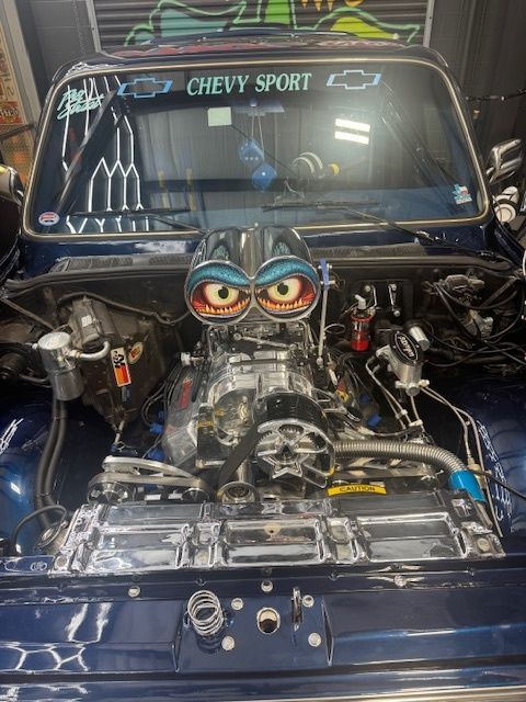 Blue Chevy Sport truck engine with chrome detailing and cartoon eye-shaped air intake. | Auto Motive