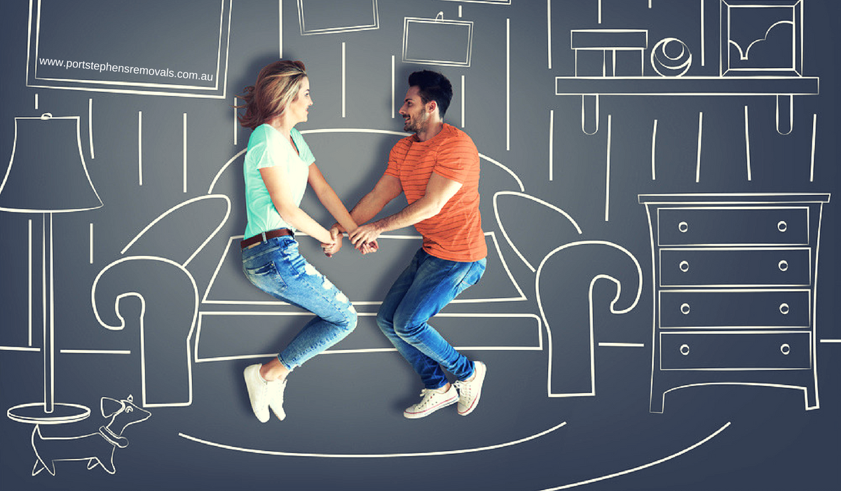 A Man And A Woman Are Laying On A Couch Holding Hands — Port Stephens Removals & Storage In Salt Ash, NSW