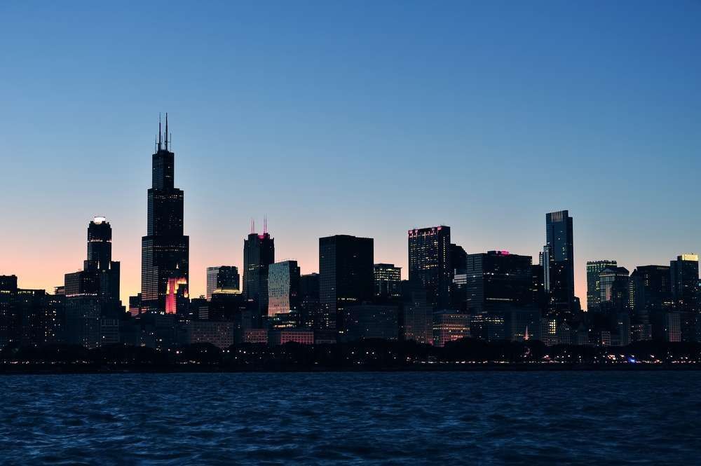Chicago skyline at dusk with the Willis Tower silhouetted above Lake Michigan