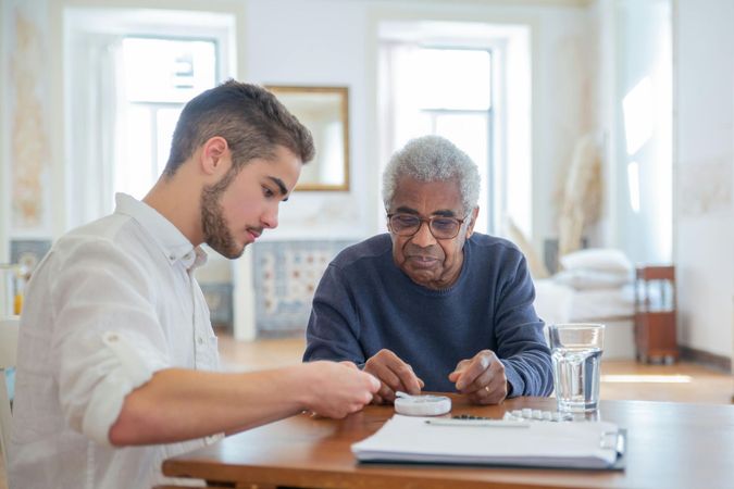 A young man is sitting at a table with an older man.
