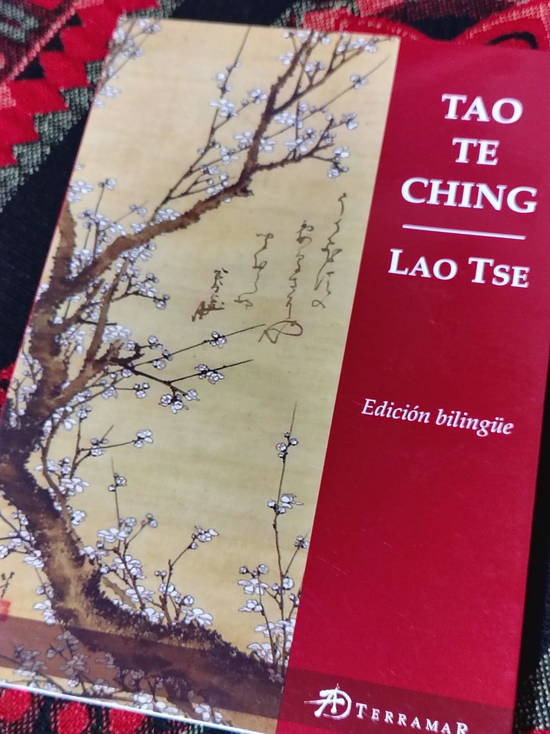 Portada del libro Tao Te Ching de Lao Tse, con una pintura a tinta de un árbol en flor sobre un fondo crema y rojo.
