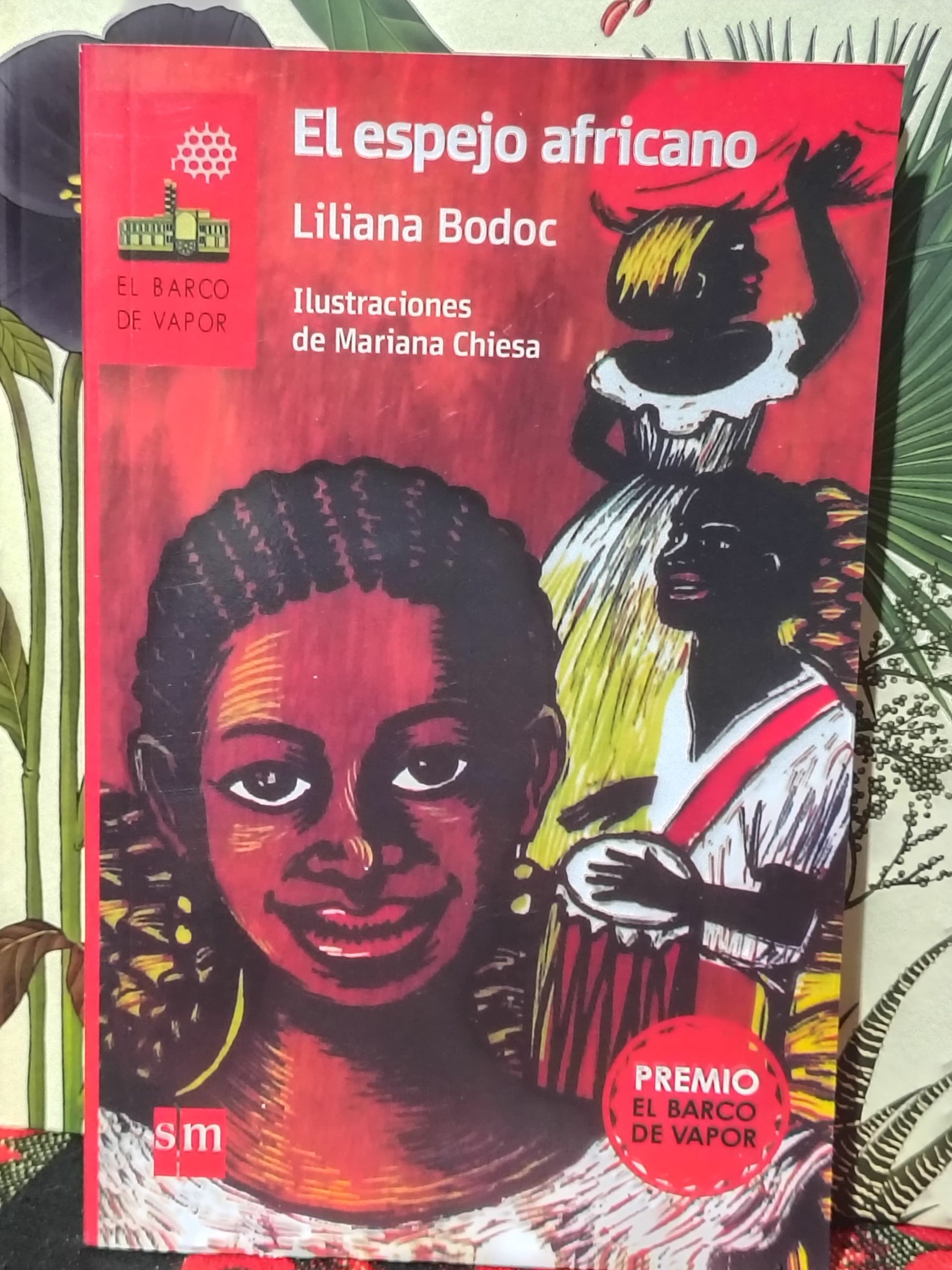 Portada del libro El espejo africano de Liliana Bodoc, con ilustraciones de tres personas en tonos cálidos y saturados.