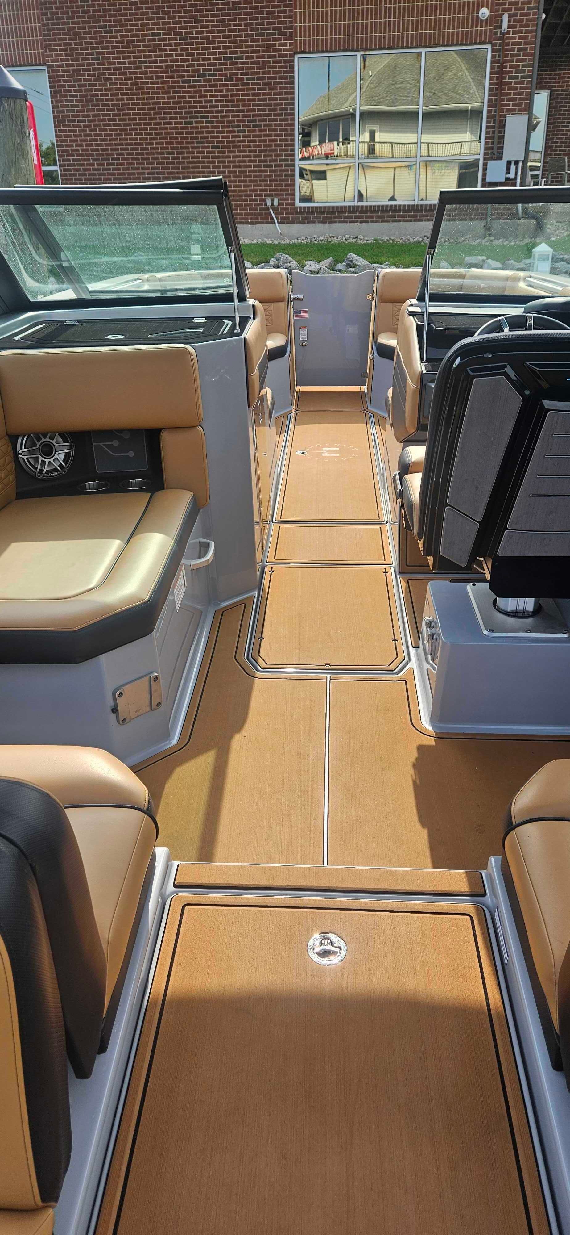 The inside of a boat with a lot of seats and a steering wheel.