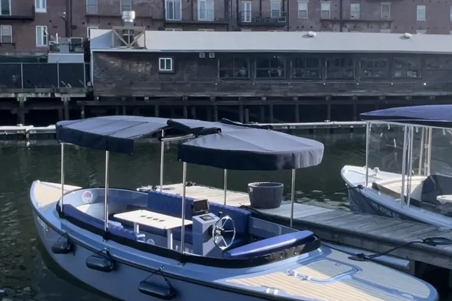 blue canopy cover on blue fantail picnic cruiser boat docked 