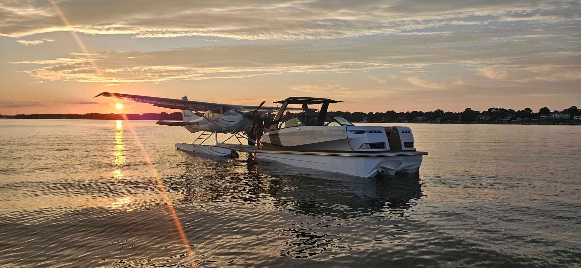 A boat is floating on top of a body of water at sunset.
