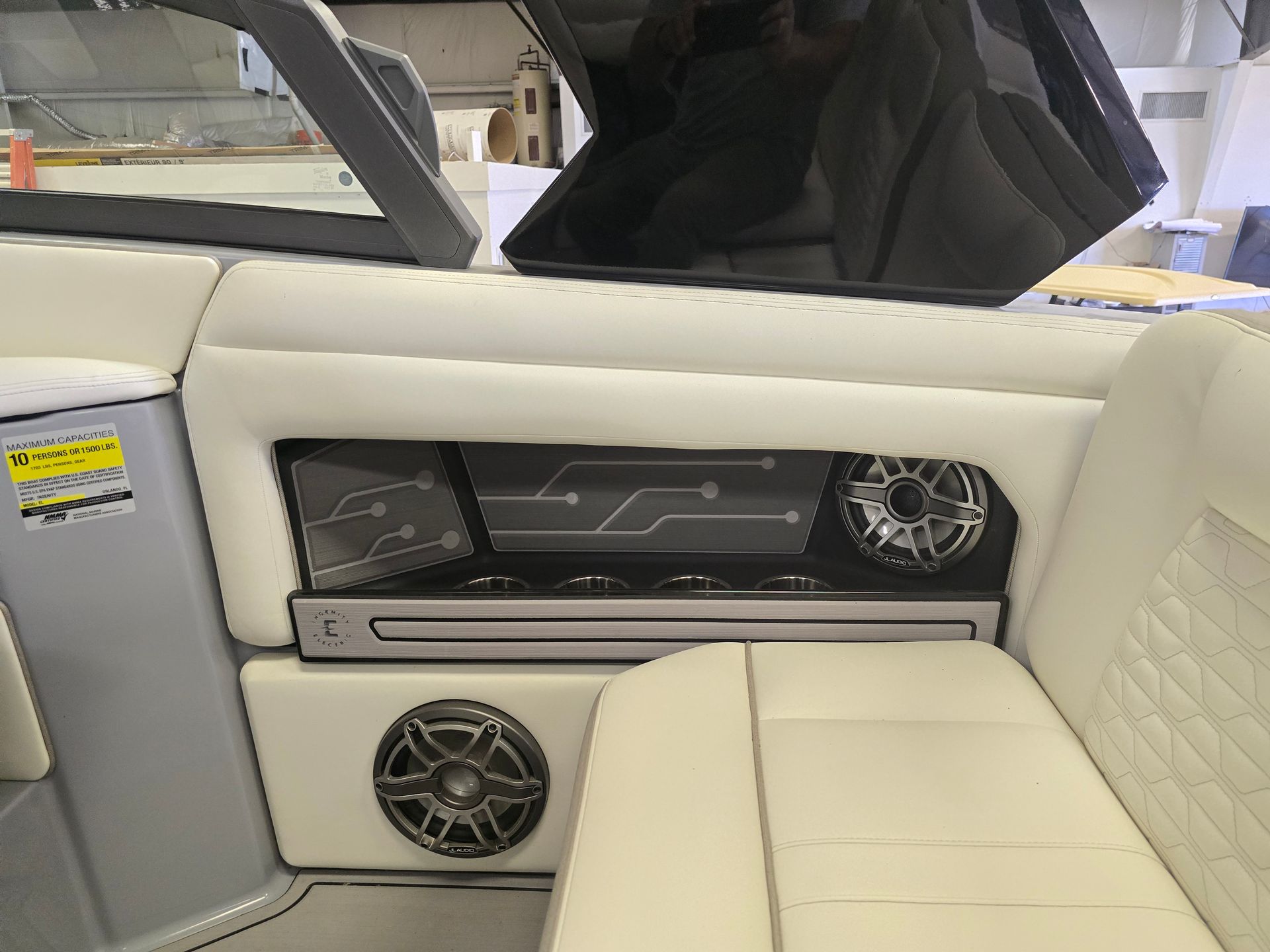 The inside of a boat with a couch and speakers.