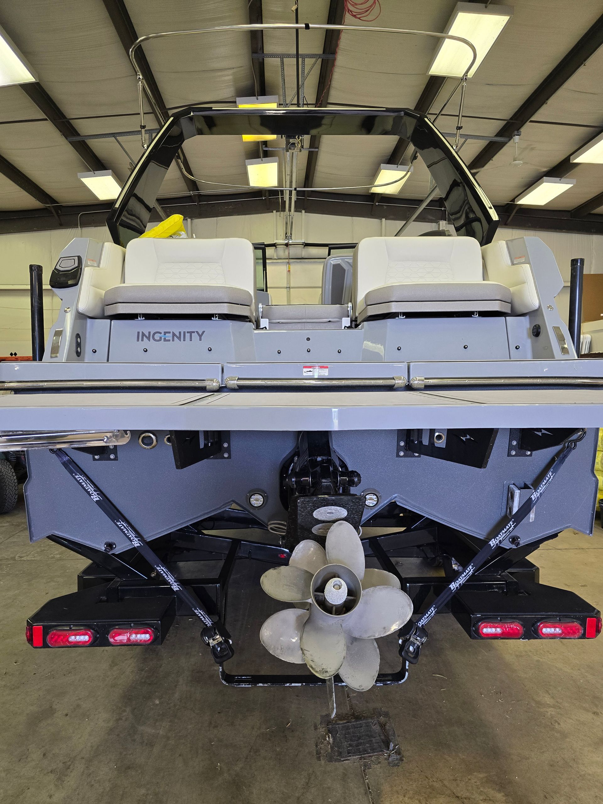 A boat with a propeller attached to it is sitting in a garage.
