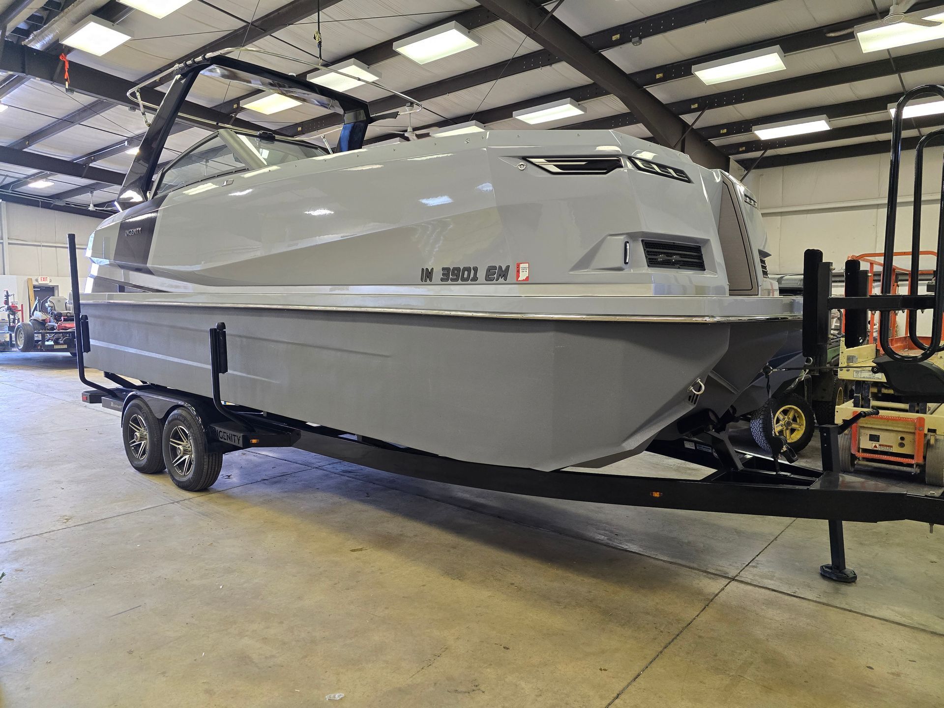 A boat is parked on a trailer in a garage.