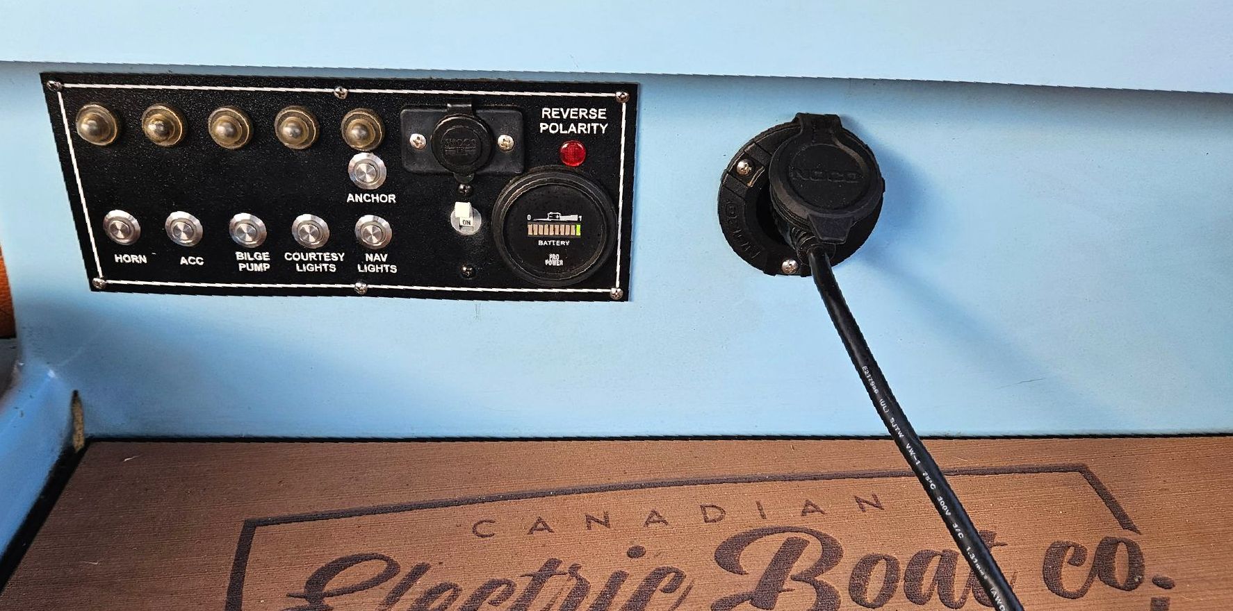 A canadian electric boat co. logo is on a cork mat