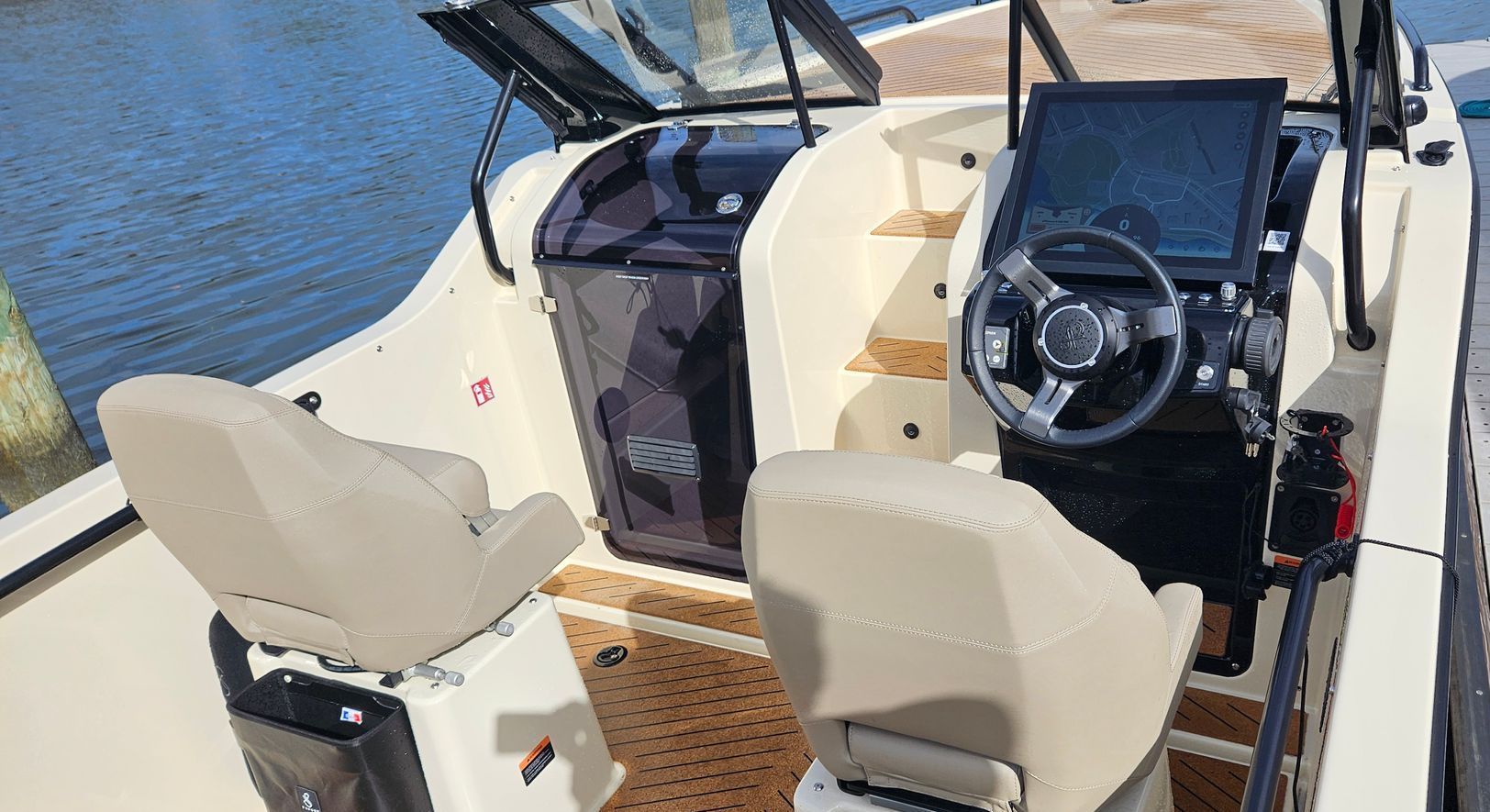 The inside of a boat with a steering wheel and seats.