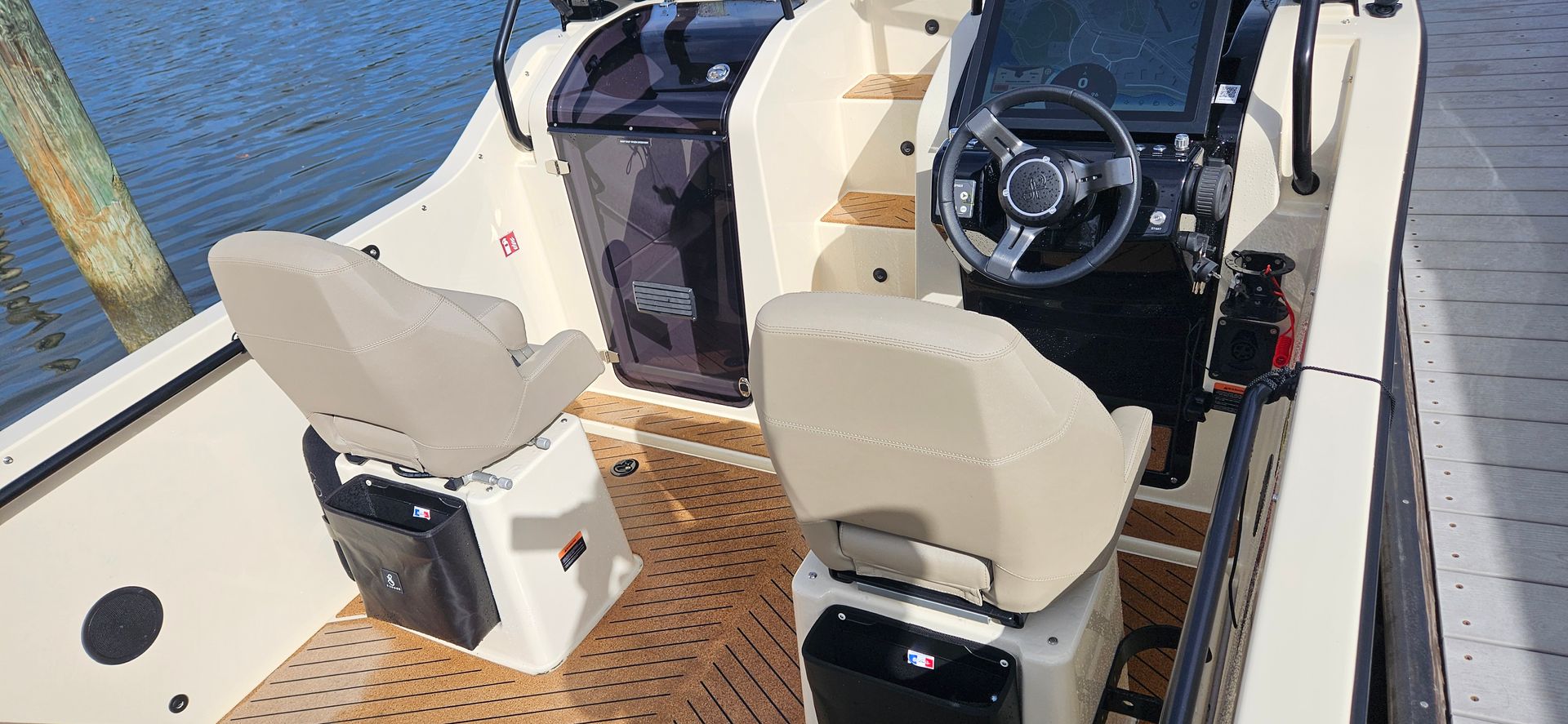 A boat is docked at a dock with a steering wheel and seats.