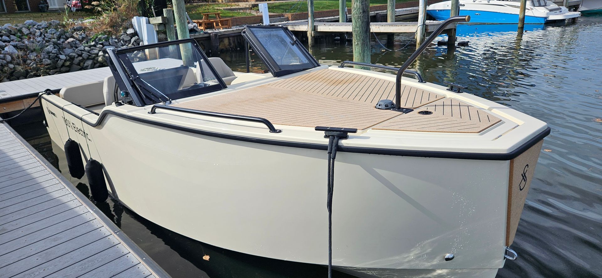 A white XShore is docked at a dock in the water.
