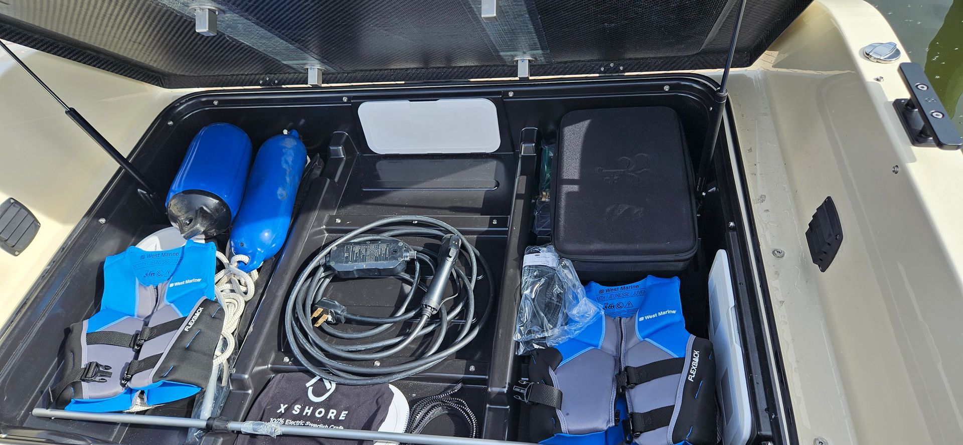 The trunk of a boat with a lot of items in it.