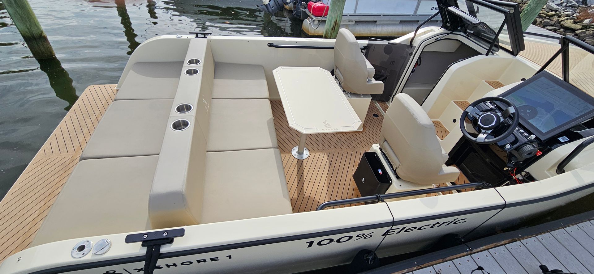XShore is docked at a dock with a table and chairs.