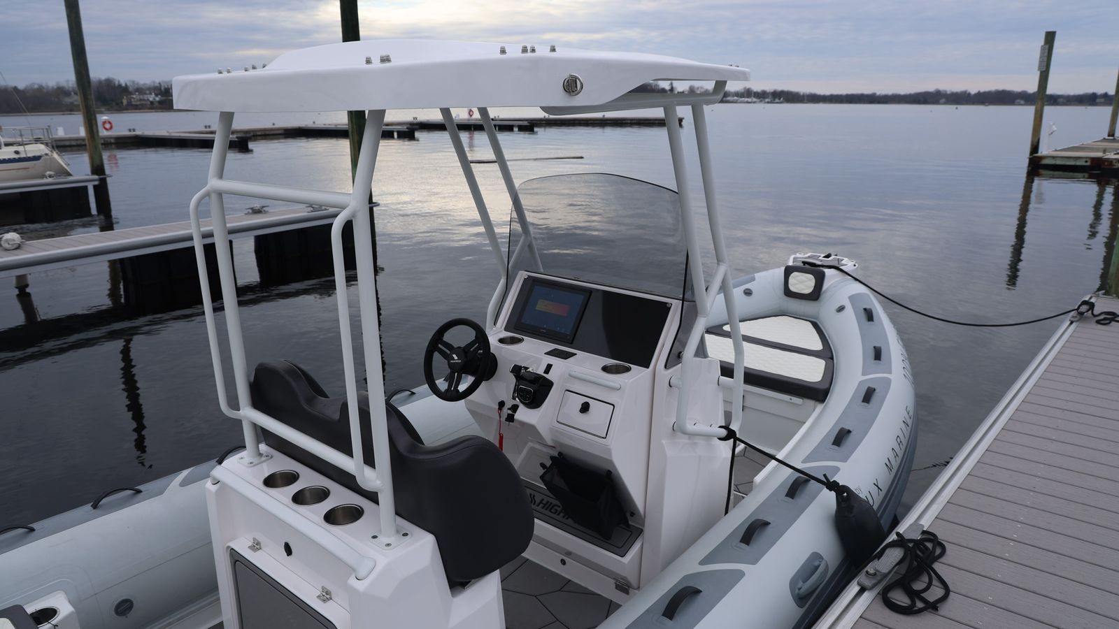 A white boat is docked at a dock in the water
