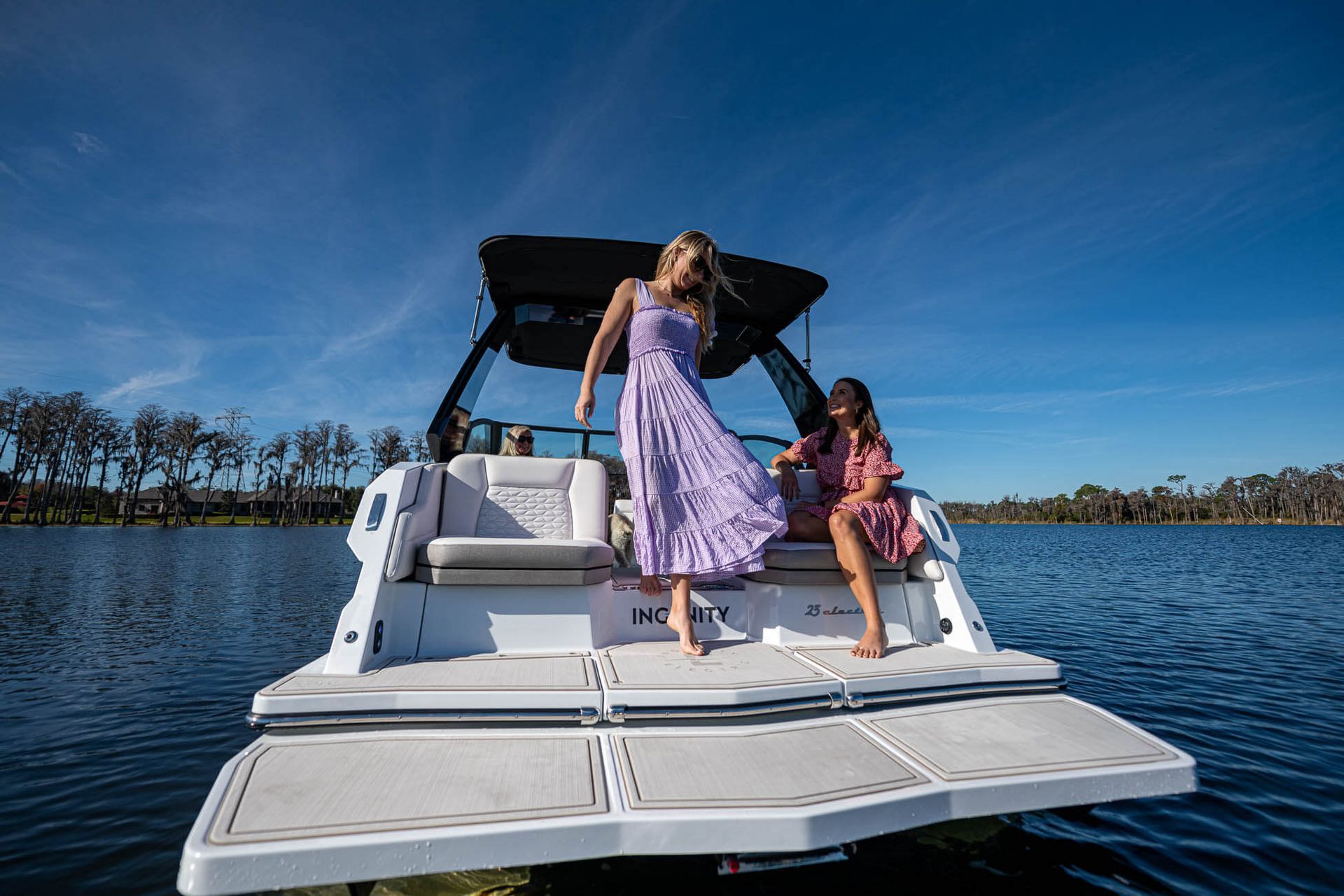 Ingenity boat with 2 ladies on the back transom