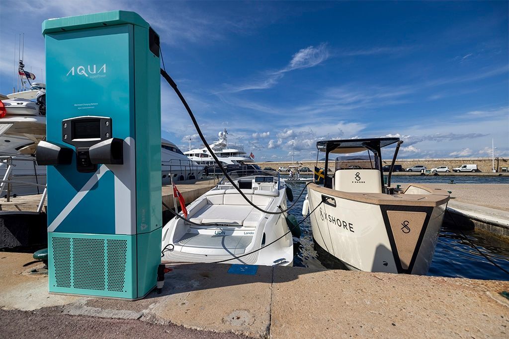A boat is being charged at a charging station in a harbor.