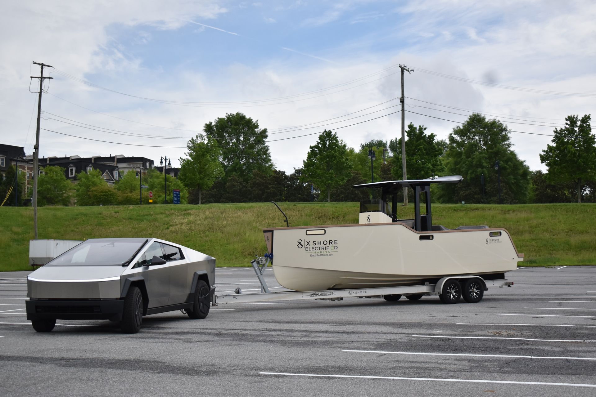 Cyber Truck towing an X Shore Eelex electric boat in a parking lot