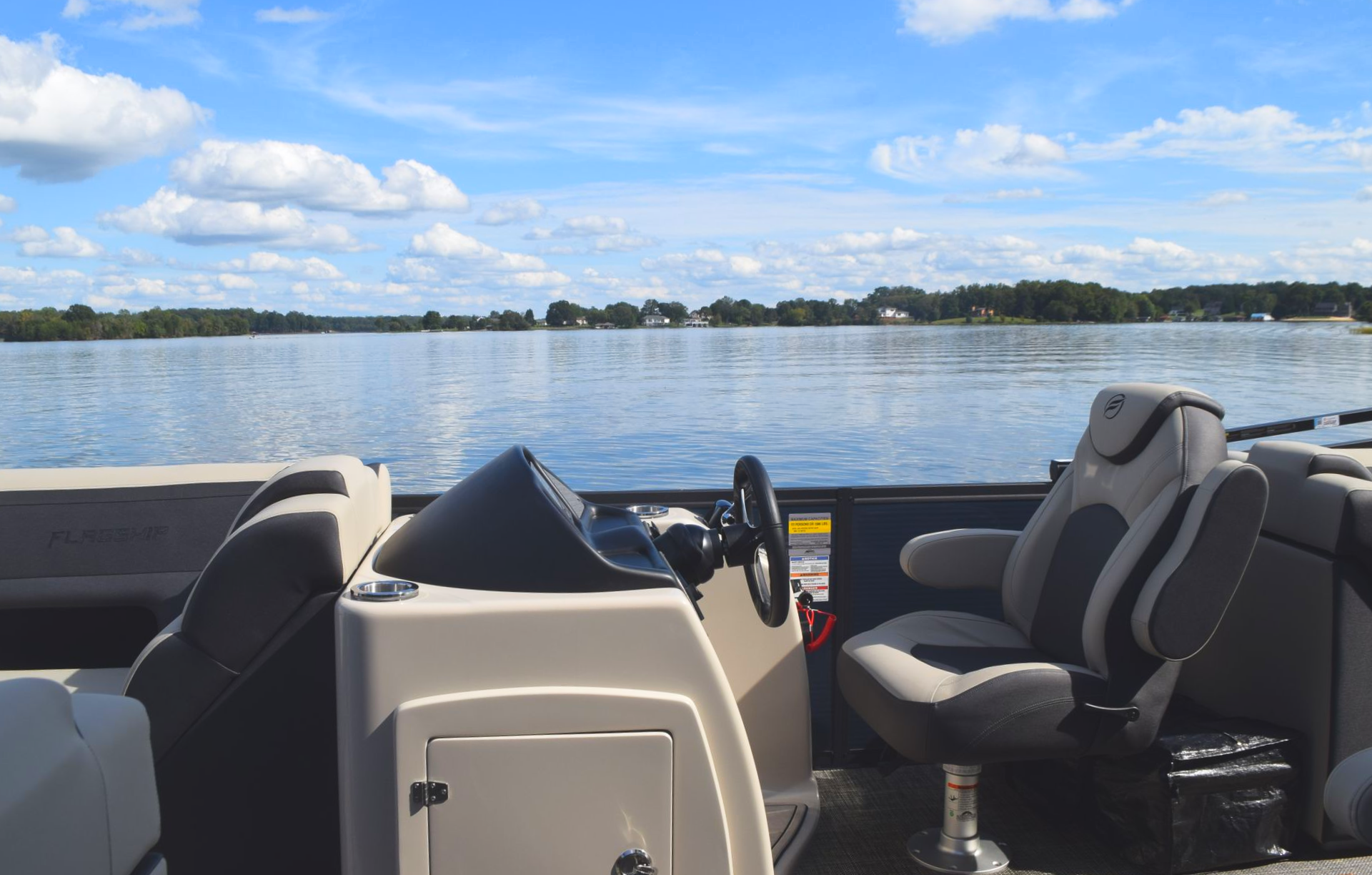 Captain chair and helm on the Flagship Discover pontoon lake in background