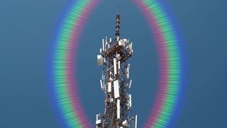 A tower with a rainbow in the sky around it