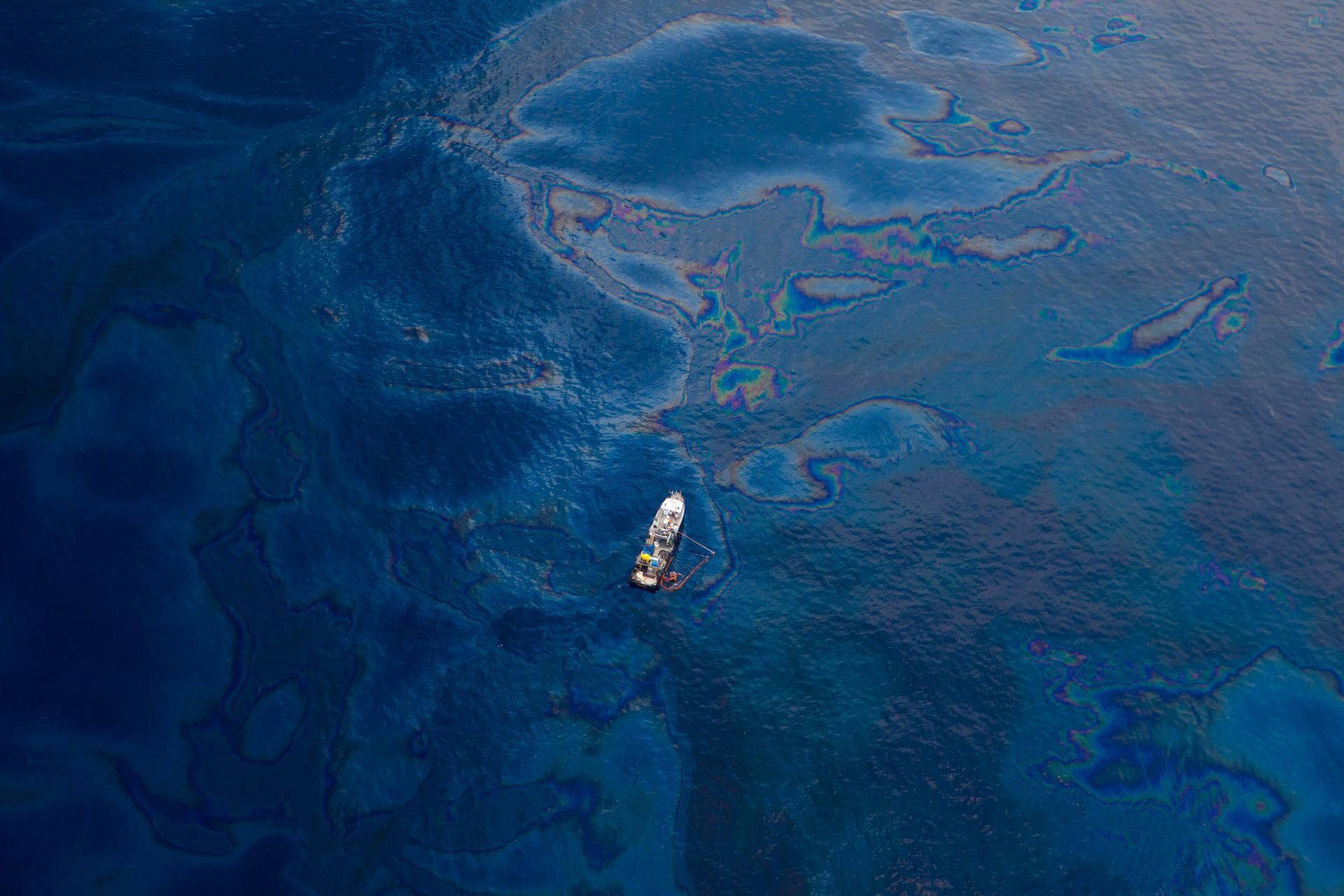 An aerial view of a boat in the middle of a large body of water.