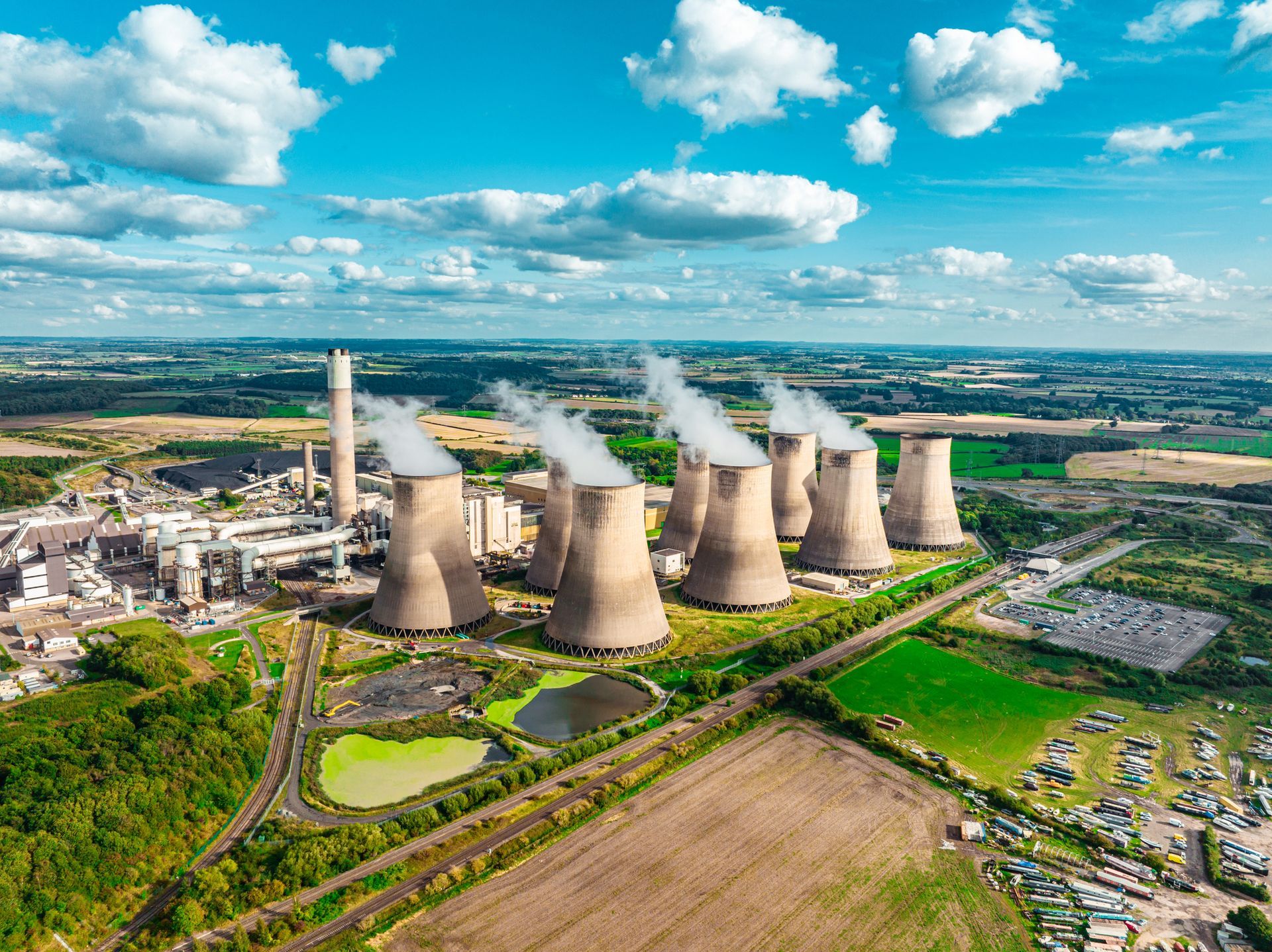 An aerial view of a nuclear power plant with smoke coming out of the cooling towers.