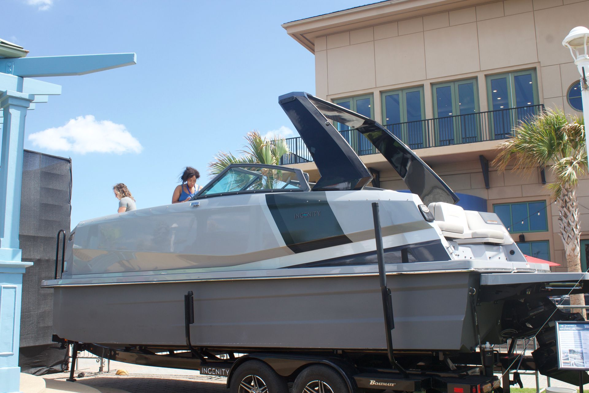 Side of grey large boat with black carbonfiber  t top over it as it sits on trailer