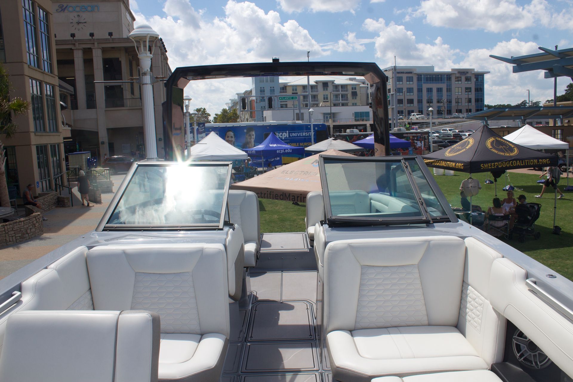 Deck layout of the Ingenity23 with white cushions and windshield with park in background 