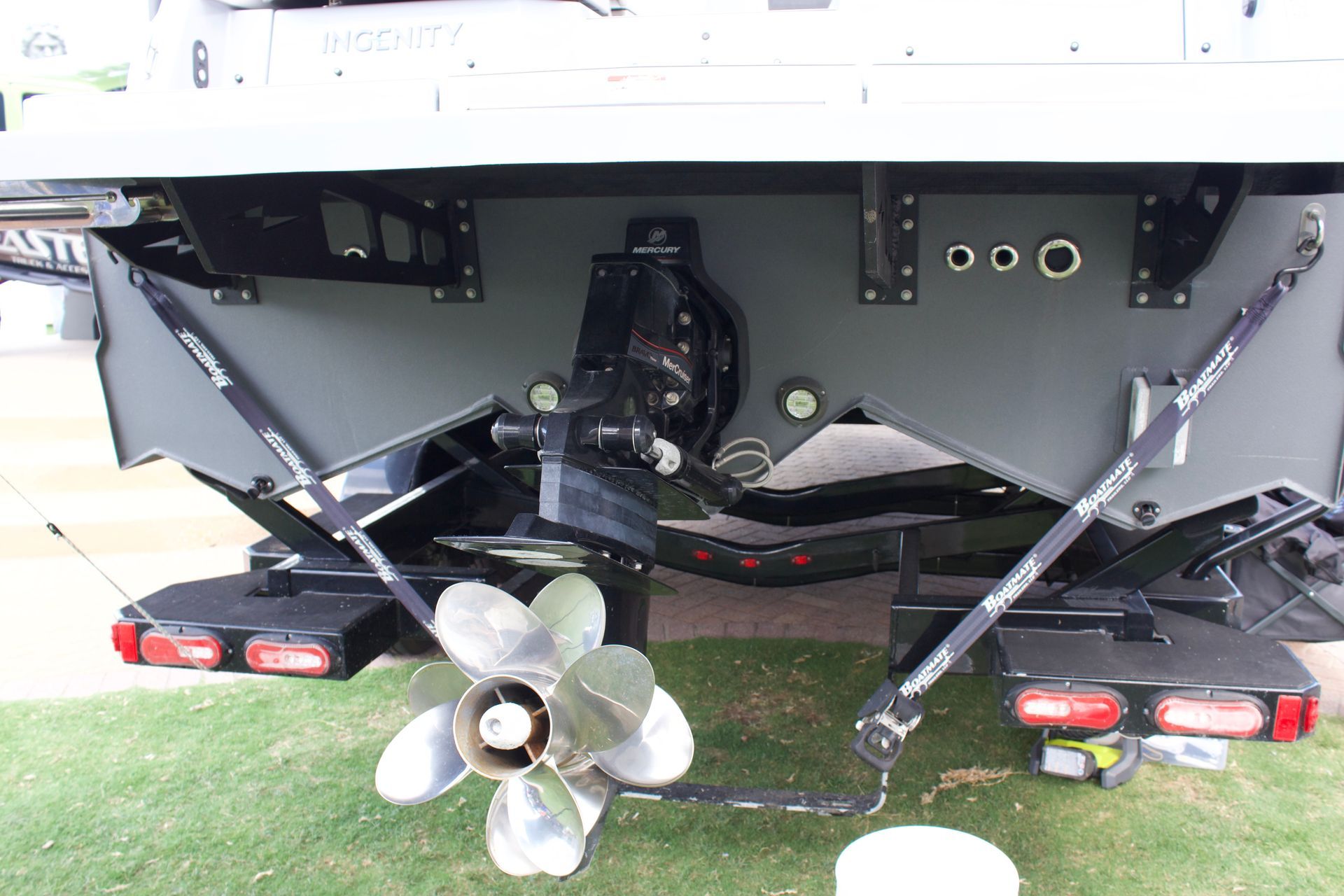 Motor and propeller of the Ingenity boat - tritoons with triangle-shaped toons that are dark grey
