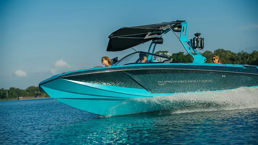 A blue boat is floating on top of a lake.