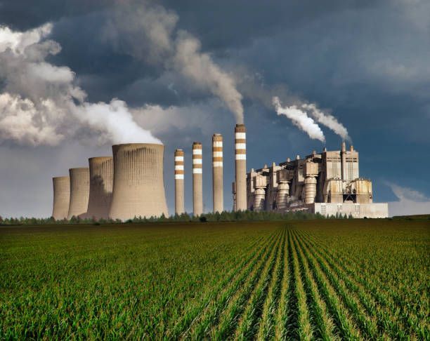 A nuclear power plant with smoke coming out of the chimneys