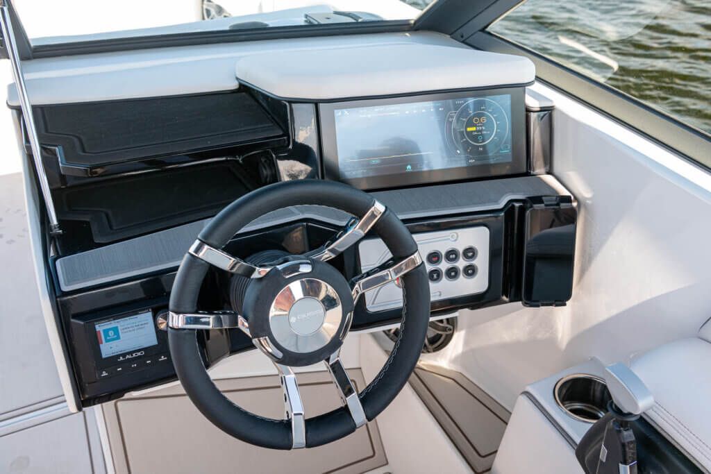 The interior of a boat with a steering wheel and dashboard.