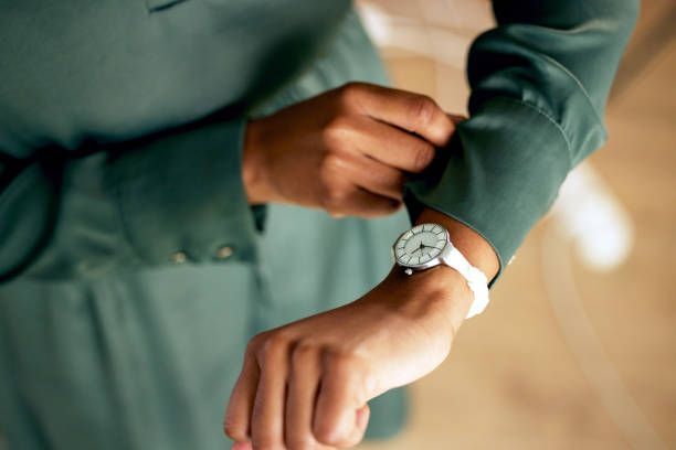 A woman is looking at her watch on her wrist.