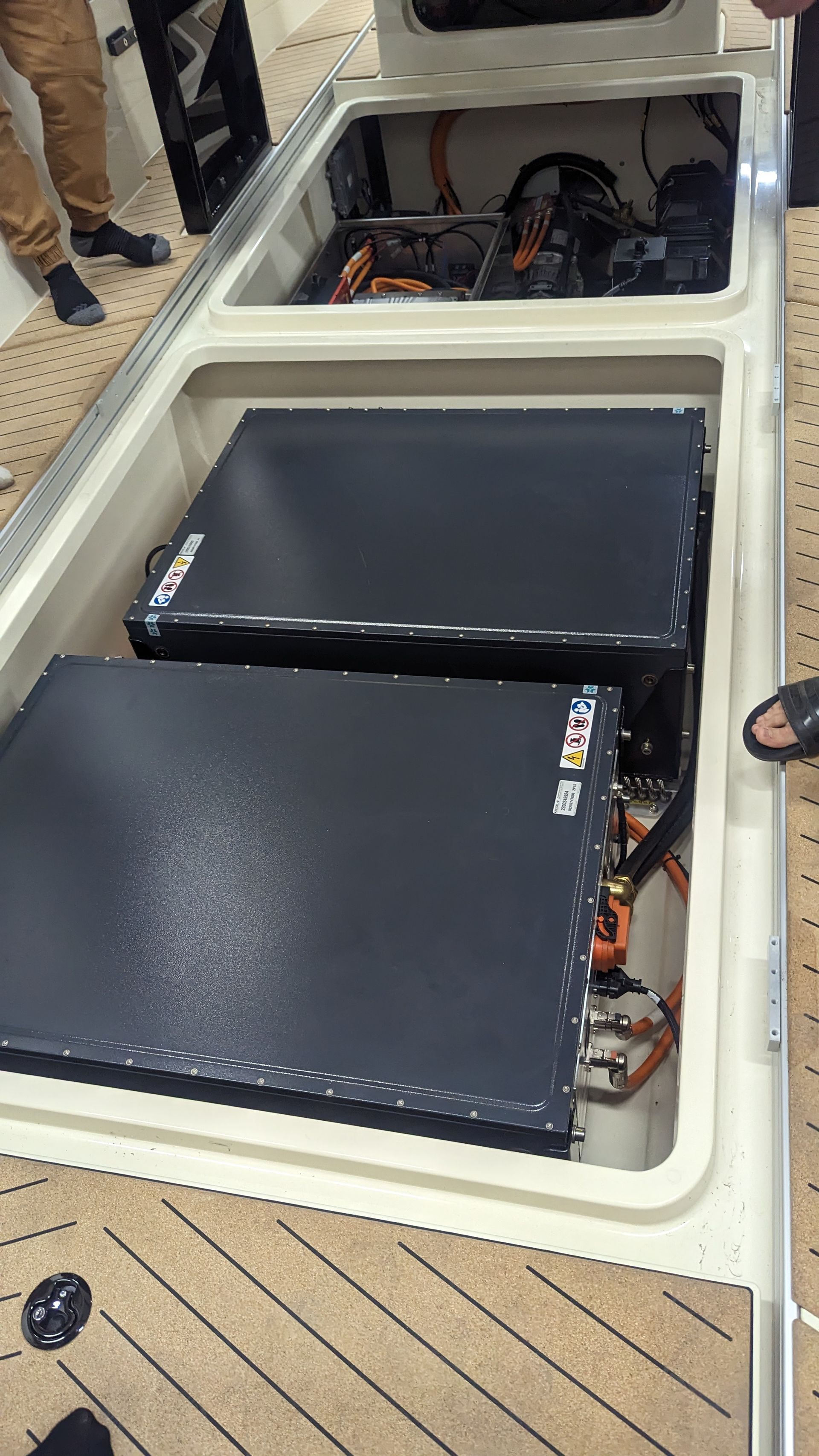 Two batteries are sitting in the trunk of a boat.