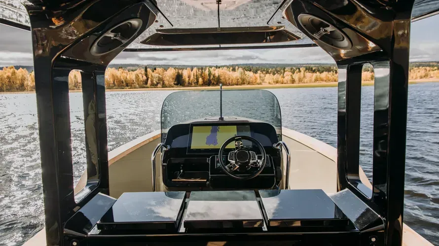 A boat is sitting in the water with a shadow on the side of it.