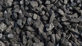 A pile of coal is sitting on the ground.