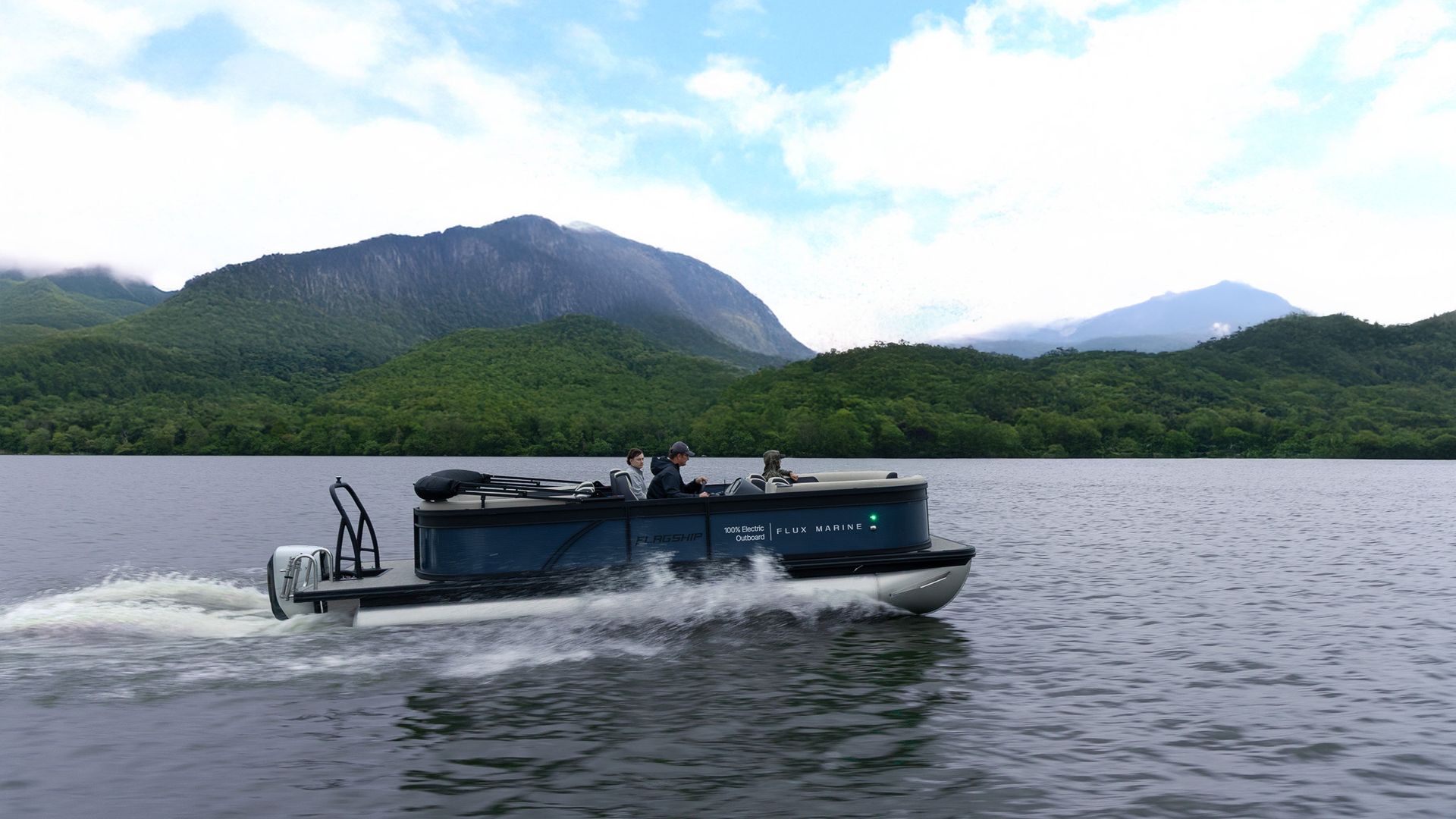 Navy blue pontoon with Flux Marine logo in white on the side and Flux electric outboard motors on the back people on boat in lake with green forest and mountains in background