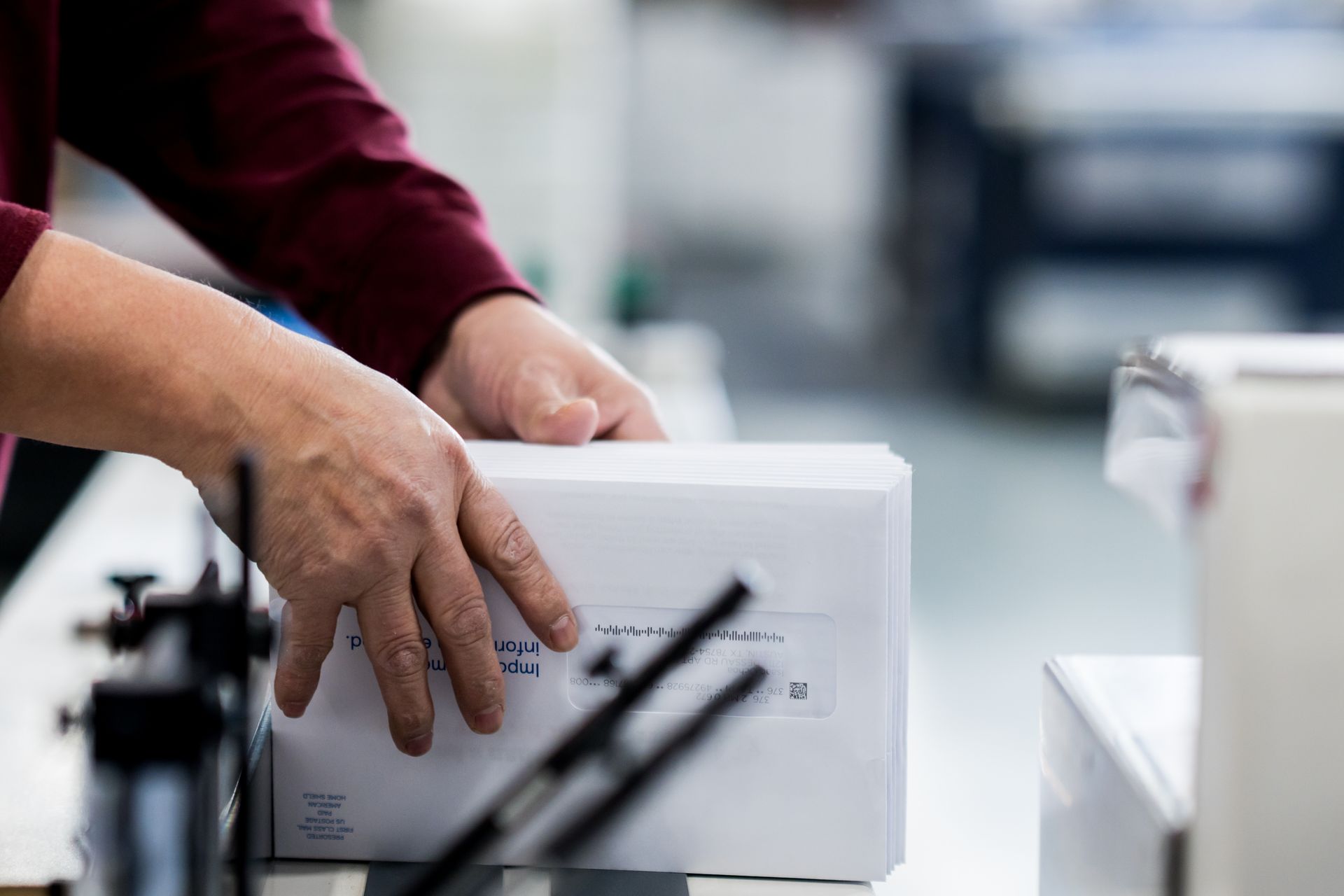 Hands moving a white package on a conveyor line in a factory