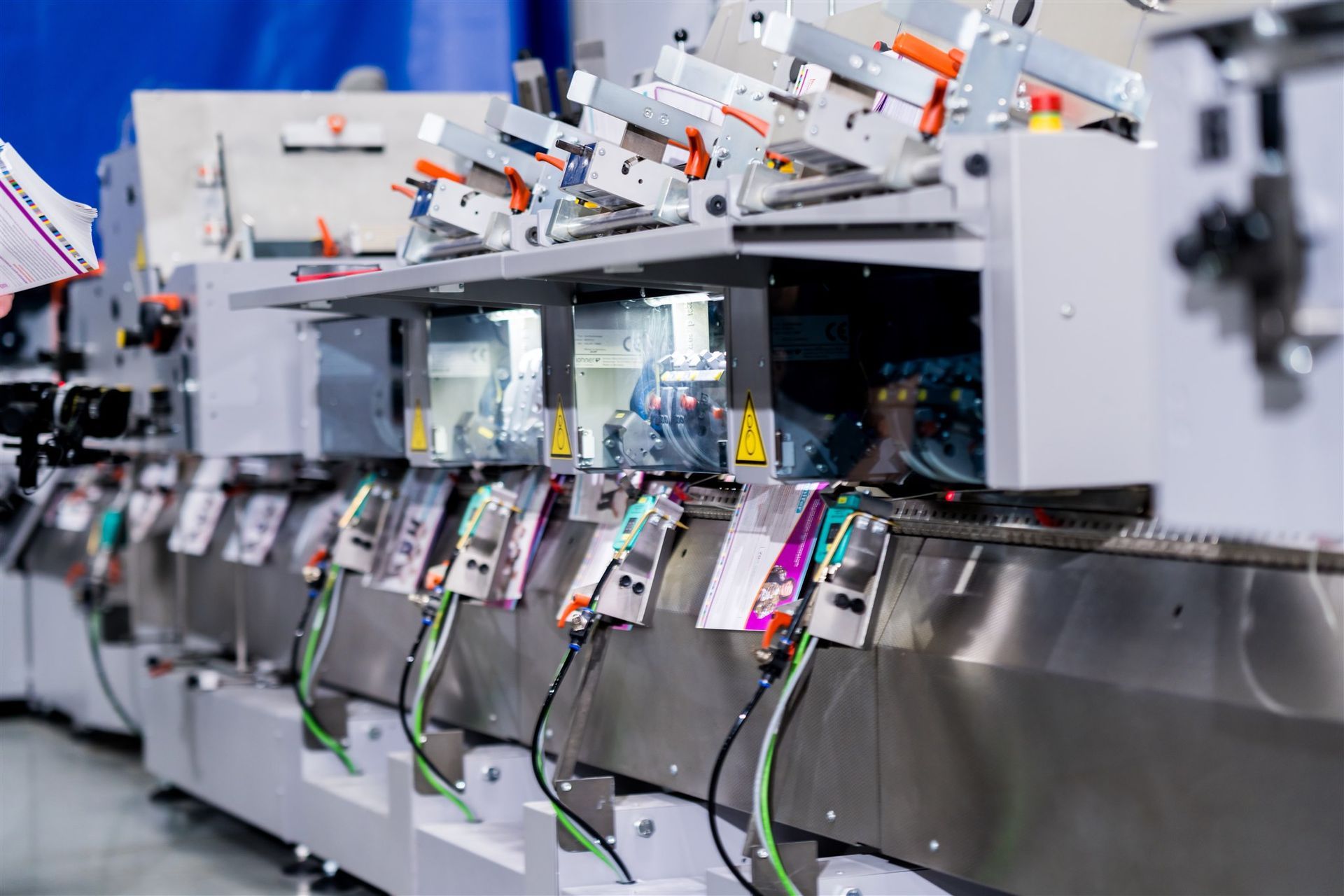 Industrial production line with rows of colorful packaged items on a stainless steel conveyor machine