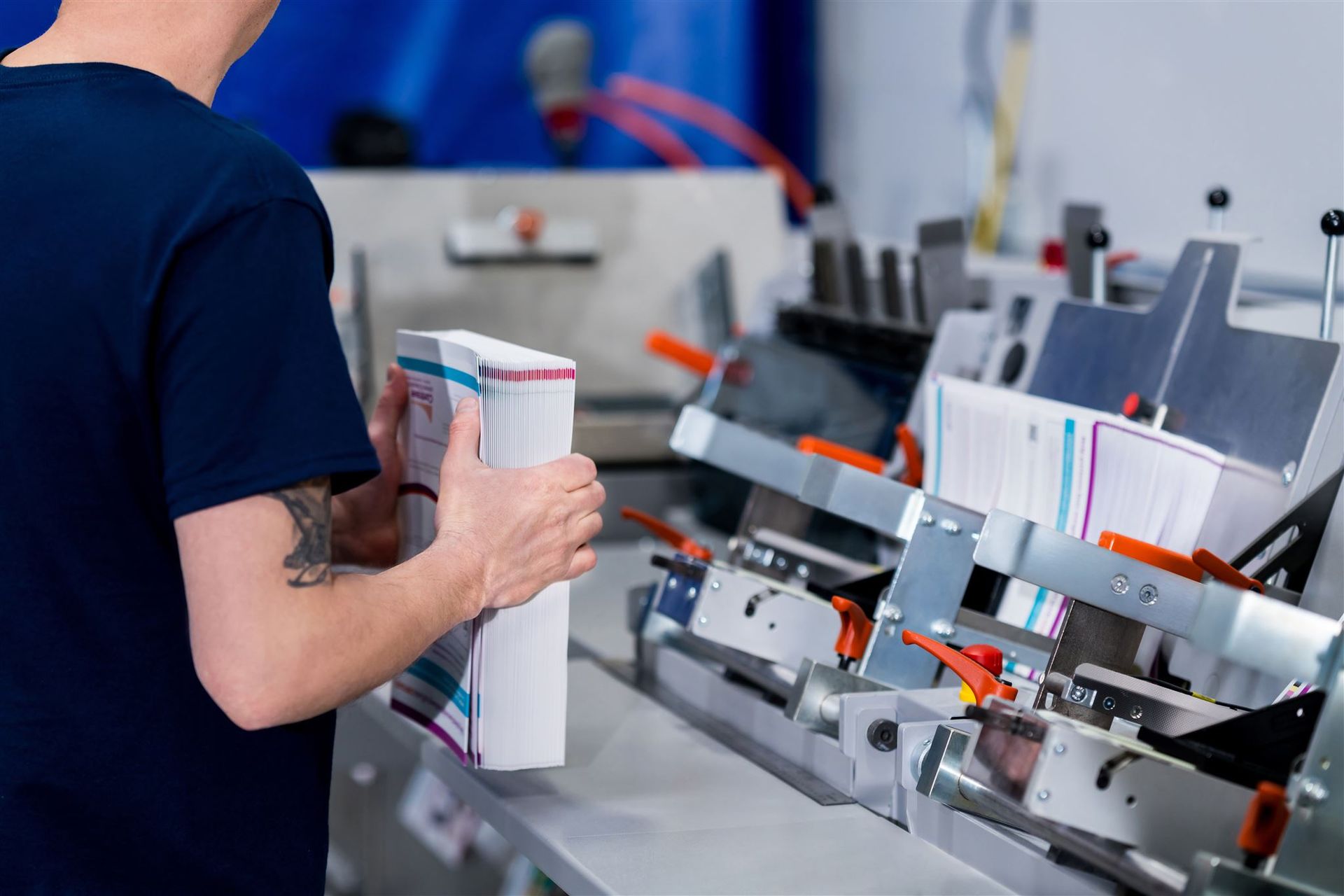 Worker loading cartons onto an industrial packaging machine