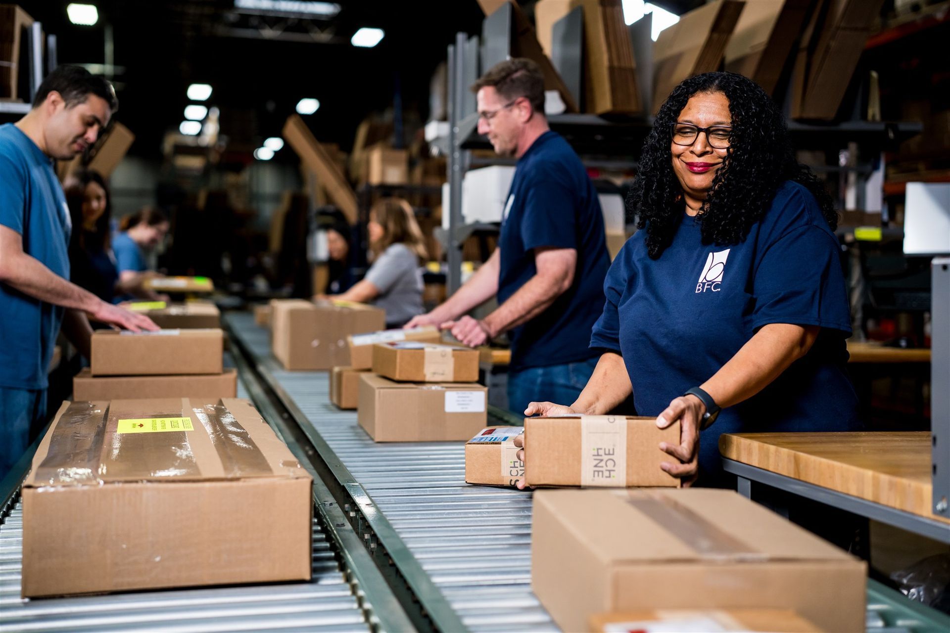 Workers packing boxes on a warehouse conveyor line