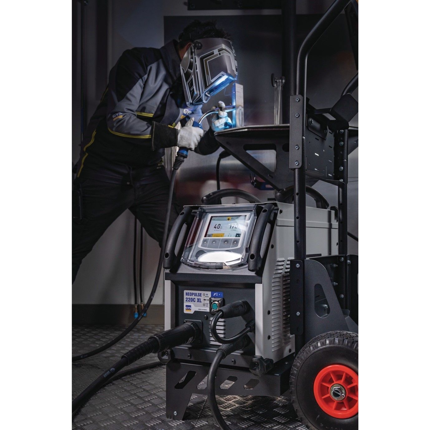 A man wearing a welding helmet is welding a piece of metal.