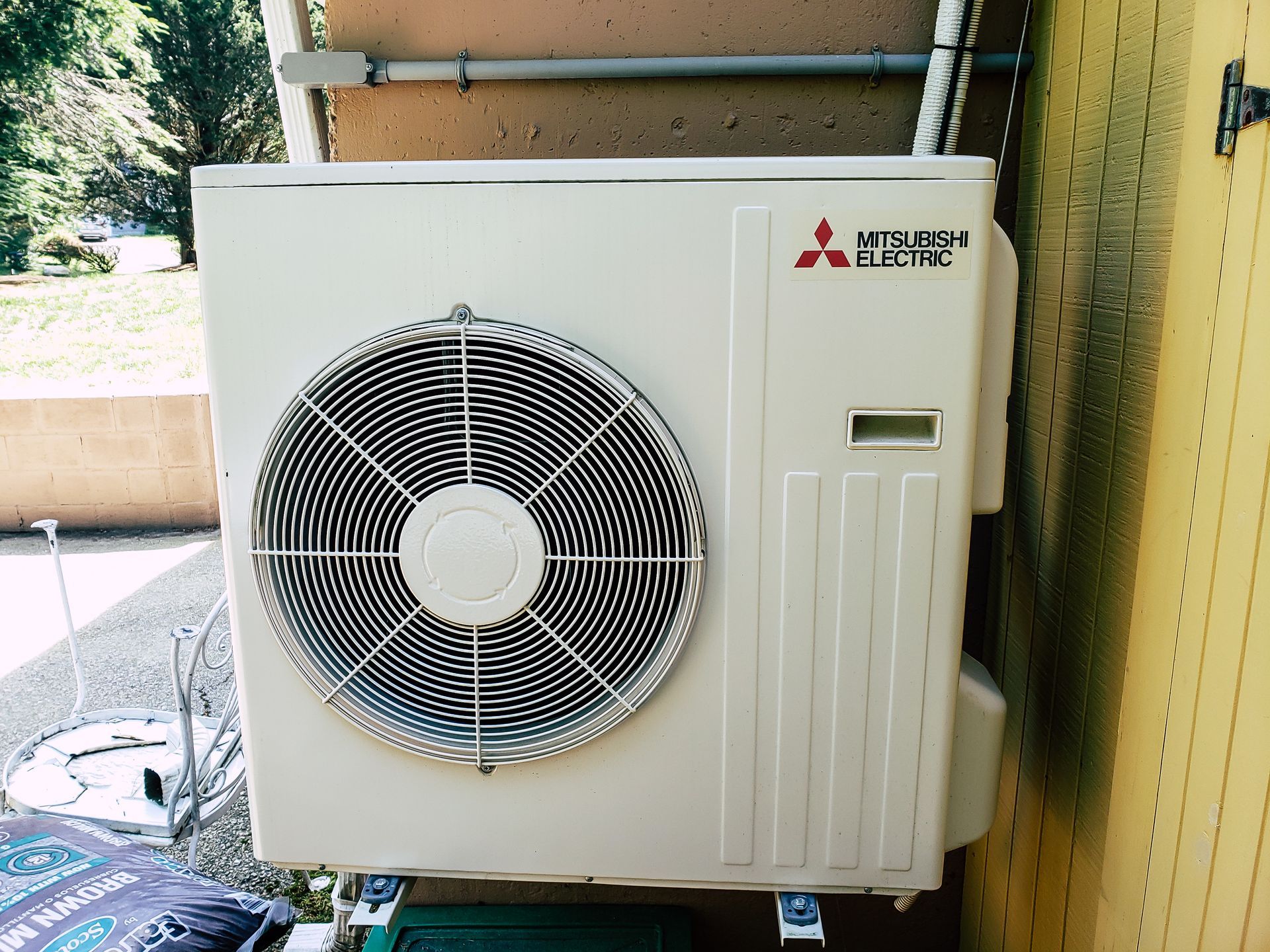 A mitsubishi air conditioner is mounted on the side of a building
